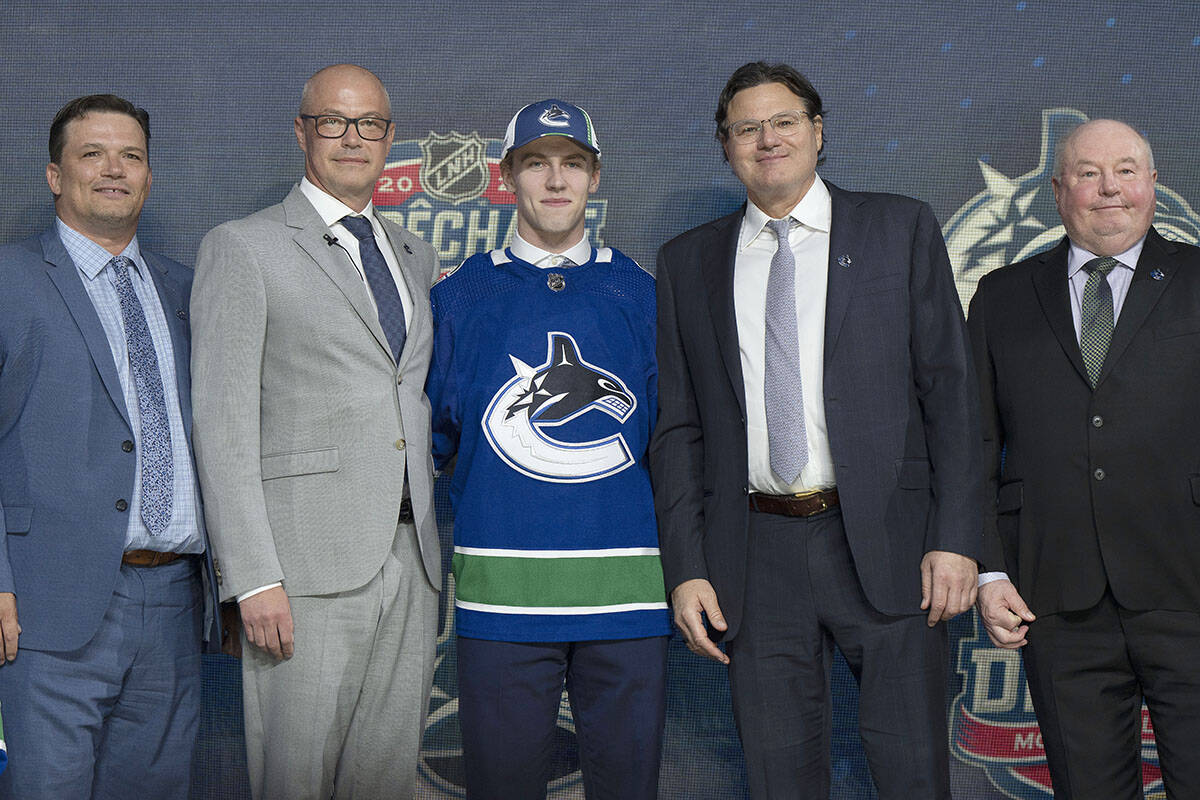 Vancouver Canucks first-round pick Jonathan Lekkerimaki poses with team officials during the first round of the 2022 NHL Draft Thursday, July 7, 2022 in Montreal. THE CANADIAN PRESS/Ryan Remiorz