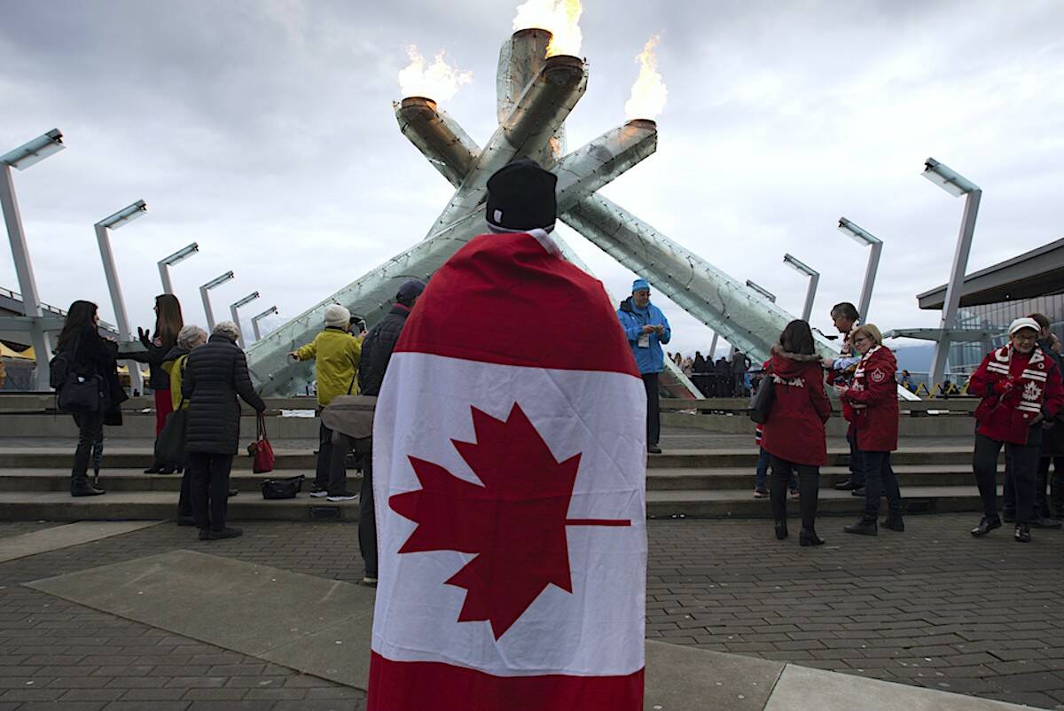 A spectator looks on as the Olympic Caldron is relit in downtown Vancouver, Wednesday, February 12, 2020. THE CANADIAN PRESS/Jonathan Hayward
