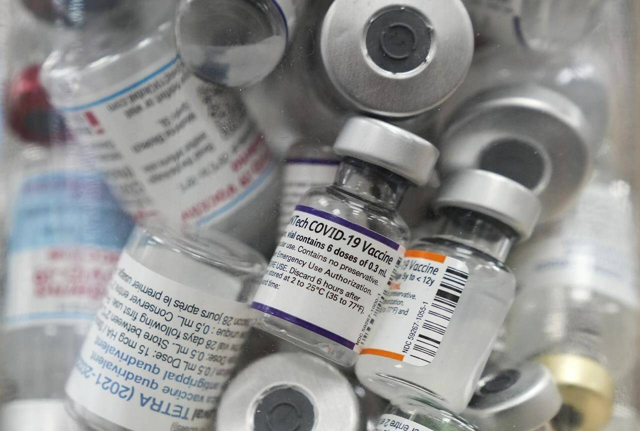 A jar full of empty COVID-19 vaccine vials is shown at the Junction Chemist pharmacy during the COVID-19 pandemic in Toronto on April 6, 2022. THE CANADIAN PRESS/Nathan Denette