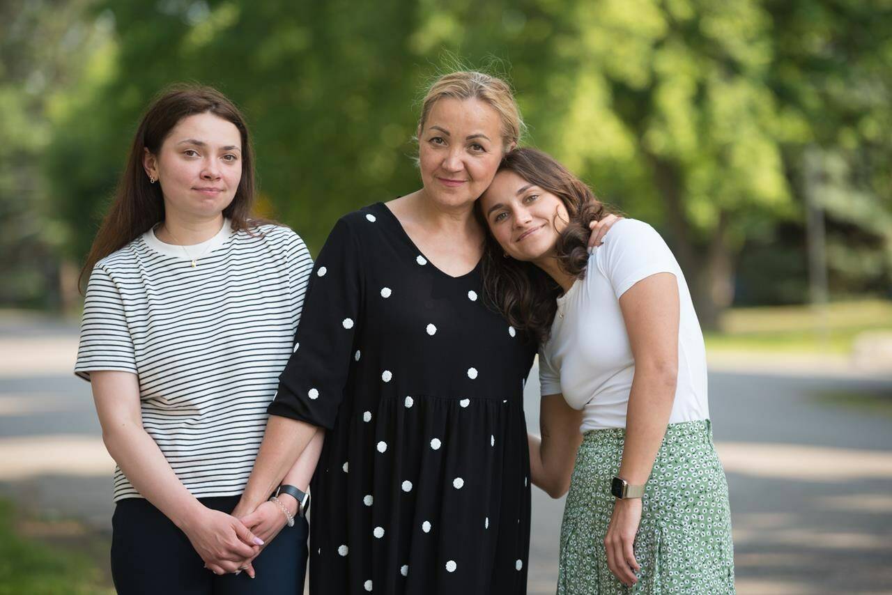 Inna Abilova, left to right, poses for a photograph with her mother, Maryna Yakovenko, and sister, Sabina Abilova, who recently arrived in Canada from Ukraine, in Etobicoke, Ont., on Thursday, June 30, 2022. THE CANADIAN PRESS/Tijana Martin