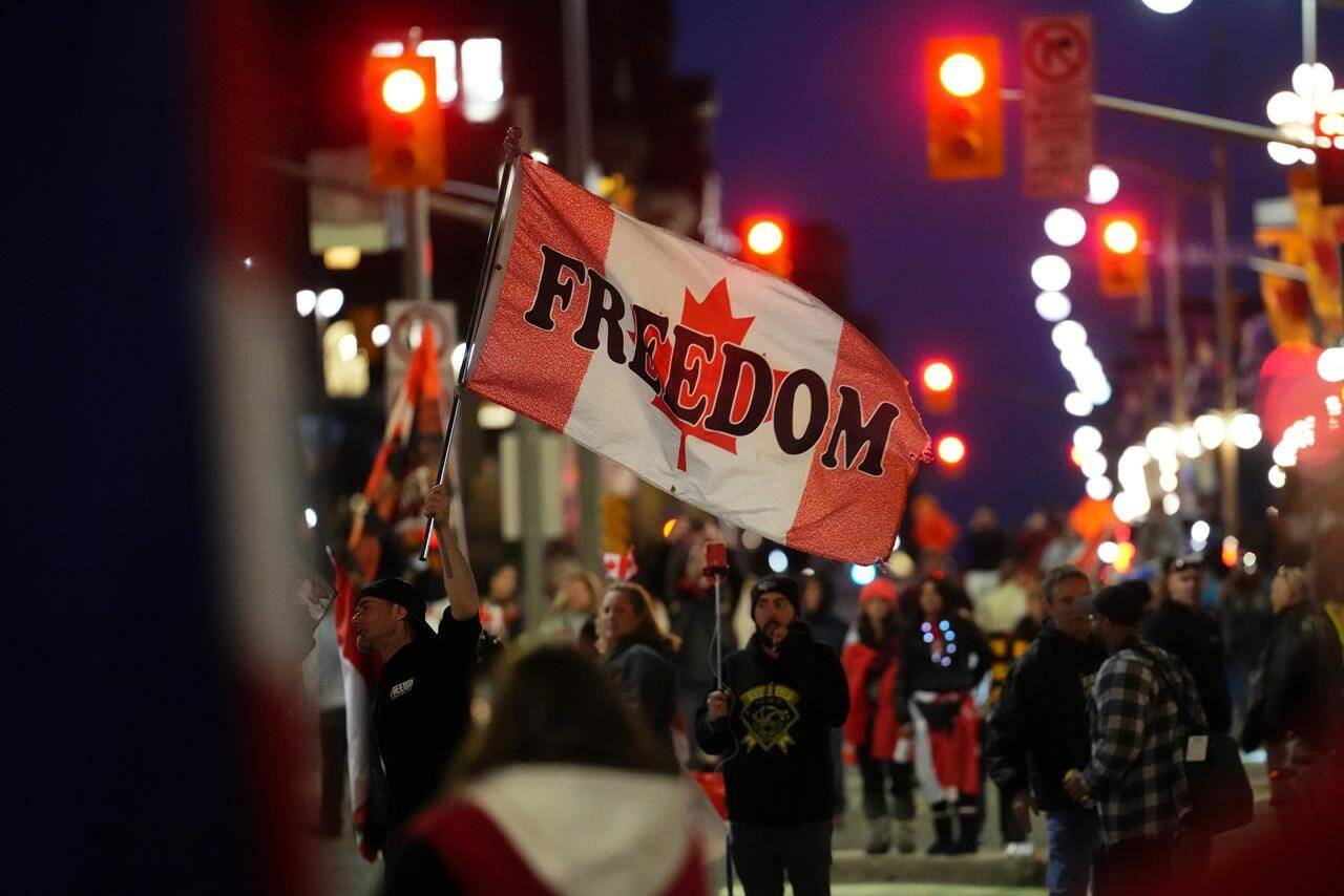 A protester waves a flag saying "freedom" during a demonstration, in Ottawa, Friday, April 29, 2022. A new national survey suggests there's a connection between Canadians' stance on free speech and their political views. THE CANADIAN PRESS/Sean Kilpatrick