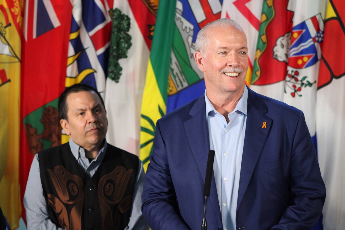 Premier John Horgan speaks alongside Songhees First Nation Chief Ron Sam (left) at a meeting between Canada’s premiers and Indigenous leaders at the Songhees Wellness Centre on July 11. (Jake Romphf/News Staff)