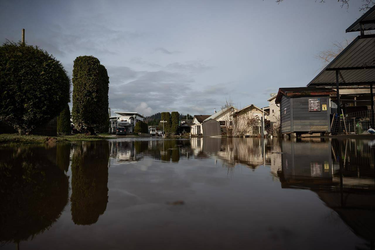 Floodwaters cover a road after water began to recede at Everglades Resort on Hatzic Lake near Mission, B.C., on Sunday, December 5, 2021. Evacuation orders have been issued for three small communities in northwestern British Columbia as the flood risk rises across the region. THE CANADIAN PRESS/Darryl Dyck