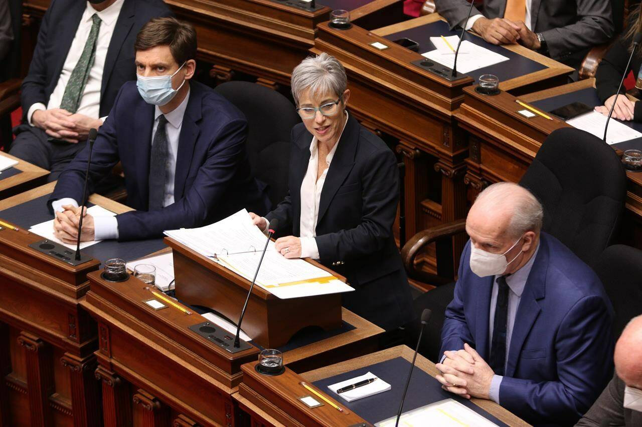British Columbia’s attorney general David Eby, left, and Premier John Horgan, look on as Finance Minister Selina Robinson delivers the budget speech in the legislative assembly in Victoria, on February 22, 2022. Robinson says she has decided not to run to replace John Horgan as premier. THE CANADIAN PRESS/Chad Hipolito