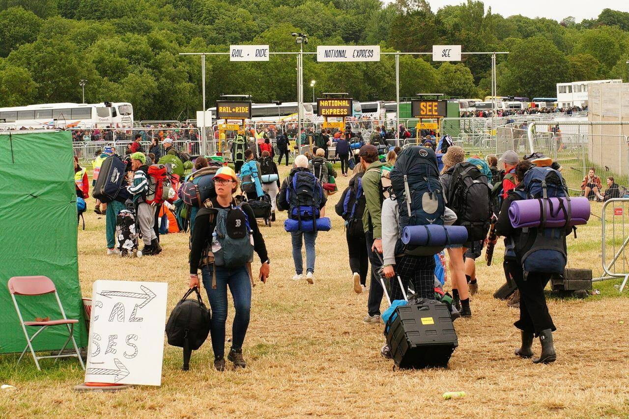 Festival goers leave Worthy Farm in Somerset, England, Monday June 27, 2022, following the Glastonbury Festival. Organizers at Canada’s summer music festivals say even as pandemic restrictions lift and live concerts return to some semblance of normalcy, it’s anything but normal behind the scenes. (Photo from the Canadian Press)