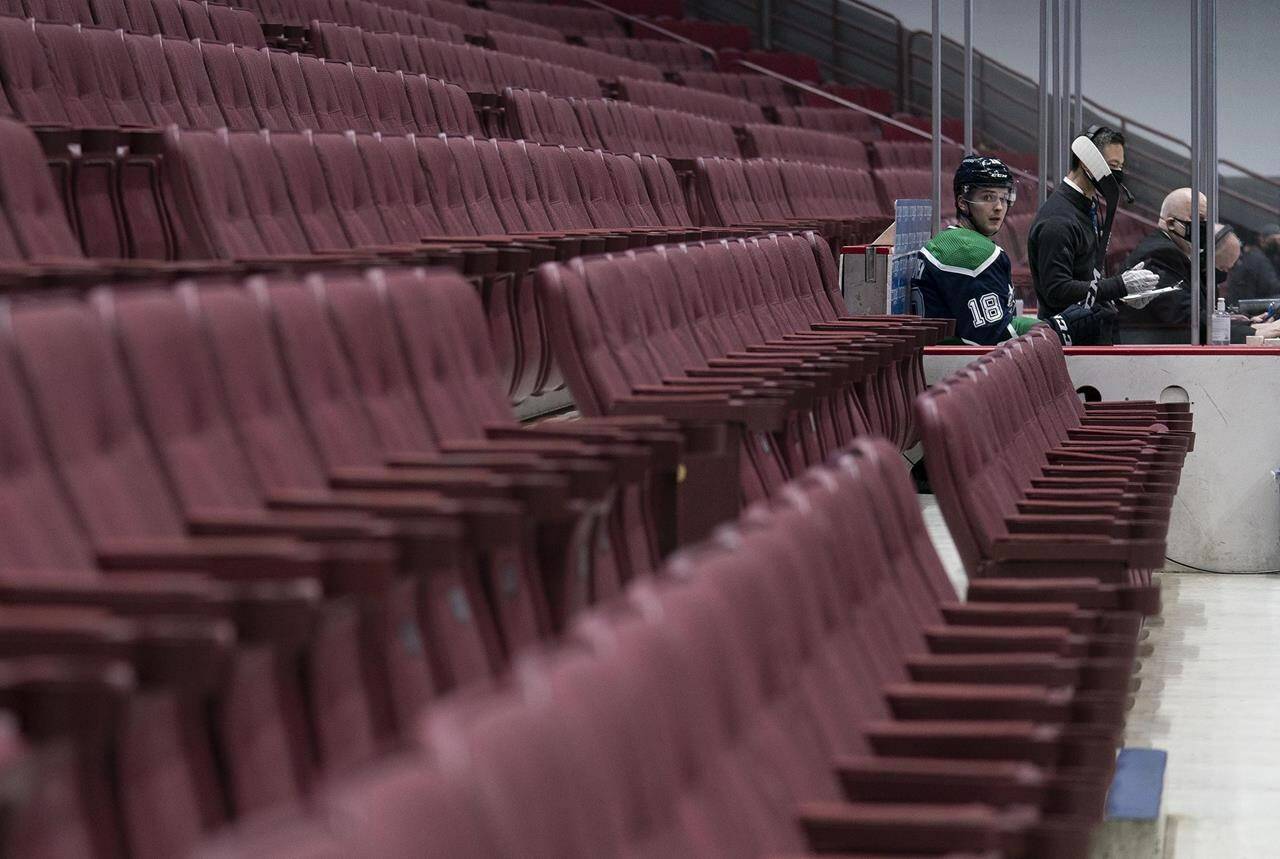 Former Vancouver Canucks right wing Jake Virtanen (18) sits in the penalty box as seats normally filled with fans remain empty during first period NHL action against the Edmonton Oilers in Vancouver, B.C., Thursday, Feb. 25, 2021. A defence lawyer is expected to cross-examine a woman today who claims she was sexually assaulted by Virtanen in 2017. THE CANADIAN PRESS/Jonathan Hayward