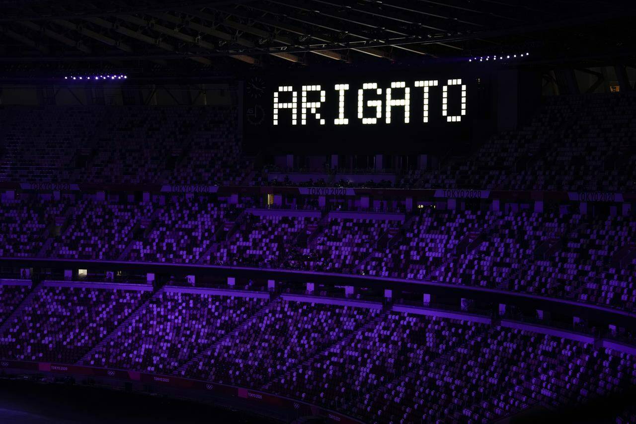 FILE - “Ariagato” is displayed at the end of the closing ceremony in the Olympic Stadium at the 2020 Summer Olympics, Sunday, Aug. 8, 2021, in Tokyo, Japan. The Tokyo Olympics survived the COVID-19 postponement, soaring expenses and some public opposition. A year later, the costs and benefits are as difficult to untangle as the Games were to pull off. (AP Photo/Vincent Thian, File)