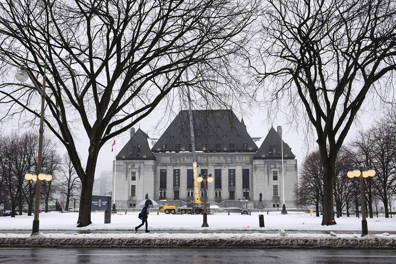 A pedestrian walks past the Supreme Court of Canada in Ottawa on Thursday, Nov. 26, 2020. Canada’s highest court has unanimously upheld the first-degree murder conviction of a man found guilty of a January 2015 slaying near Prince George, B.C. THE CANADIAN PRESS/Sean Kilpatrick