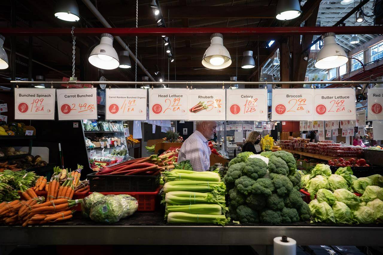 People shop for produce at the Granville Island Market in Vancouver, on Wednesday, July 20, 2022. As the cost of living rises at the fastest pace in decades, Canadians struggling to put food on the table are turning to community organizations for help. THE CANADIAN PRESS/Darryl Dyck