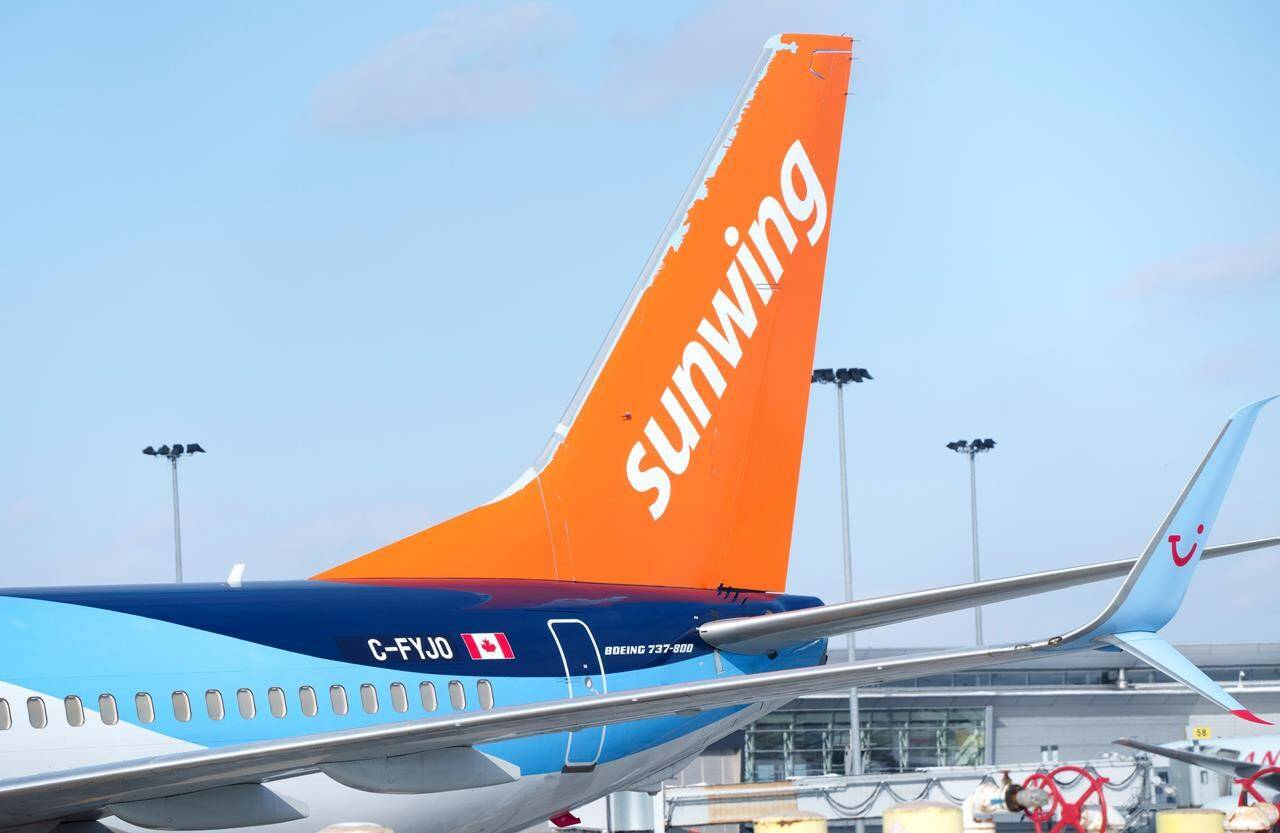 A Sunwing aircraft is parked at Montreal Trudeau airport in Montreal on Wednesday, March 2, 2022. Unifor says the Canadian government should block the WestJet Group’s takeover of Sunwing Airlines Inc. unless it can guarantee job creation and investments in workers. THE CANADIAN PRESS/Paul Chiasson