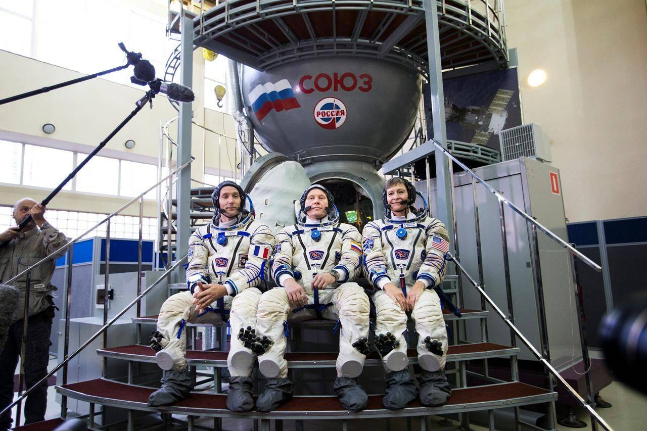 FILE - ESA French astronaut Thomas Pesquet, left, Russian cosmonaut Oleg Novitsky, center, and U.S. astronaut Peggy Annette Whitson pose for a photo before their final preflight practical examination in a mock-up of a Soyuz space craft at Russian Space Training Center in Star City, outside Moscow, Russia, Tuesday, Oct. 25, 2016. Russia will opt out of the International Space Station after 2024 and focus on building its own orbiting outpost, the country’s newly appointed space chief said Tuesday, July 26, 2022. (AP Photo/Ivan Sekretarev, File)