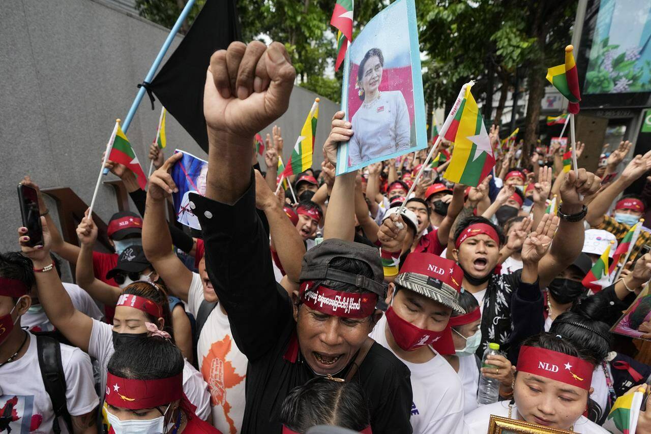 Myanmar nationals living in Thailand with a picture of deposed Myanmar leader Aung San Suu Kyi, seen at center, stage a rally outside Myanmar’s embassy in Bangkok, Thailand, Tuesday, July 26, 2022. International outrage over Myanmar’s execution of four political prisoners is intensifying with grassroots protests and strong condemnation from world governments. (AP Photo/Sakchai Lalit)