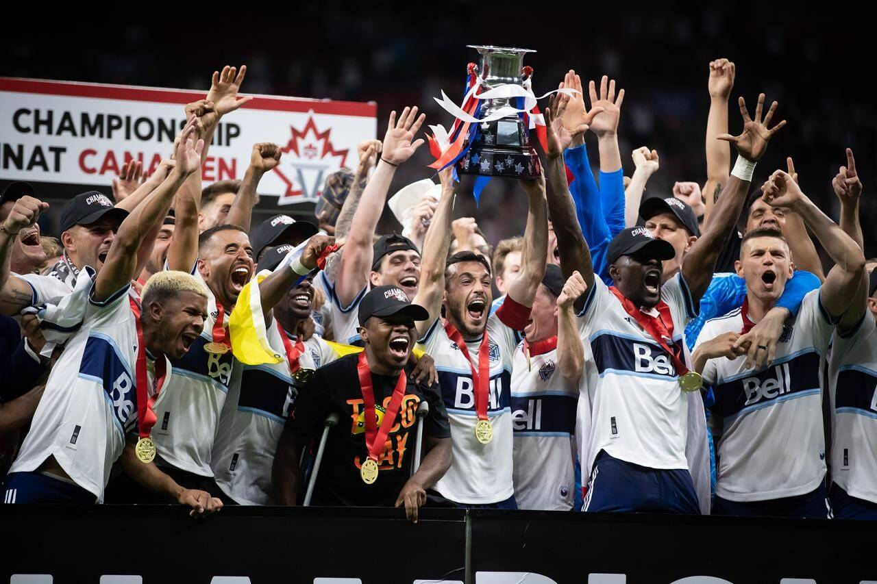 Vancouver Whitecaps’ Russell Teibert, centre, hoists the Voyageurs Cup after Vancouver defeated Toronto FC in penalty kicks during the Canadian Championship soccer final, in Vancouver, on Tuesday, July 26, 2022. THE CANADIAN PRESS/Darryl Dyck