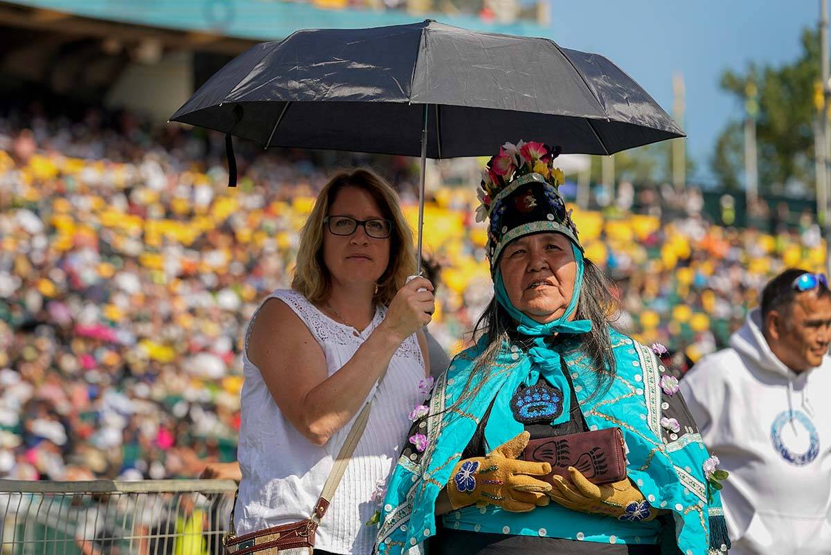 Two women listen as Pope Francis delivers an open air Mass at Commonwealth Stadium, Tuesday, July 26, 2022, in Edmonton, Alberta. Pope Francis traveled to Canada to apologize to Indigenous peoples for the abuses committed by Catholic missionaries in the country’s notorious residential schools. (AP Photo/Eric Gay)