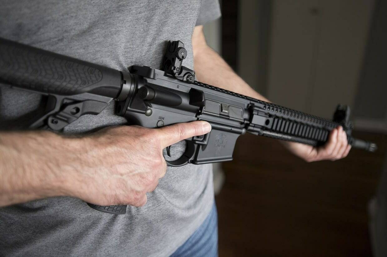 A restricted gun licence holder holds a AR-15 at his home in Langley, B.C. on May 1, 2020. A leading proponent of stricter gun control says allowing owners of recently banned firearms to keep them would make it easier for a different government to reverse the ban in future. In a letter to Public Safety Minister Bill Blair, the group PolySeSouvient urges the Liberal government to implement a mandatory buyback program for all assault-style guns. THE CANADIAN PRESS/Jonathan Hayward