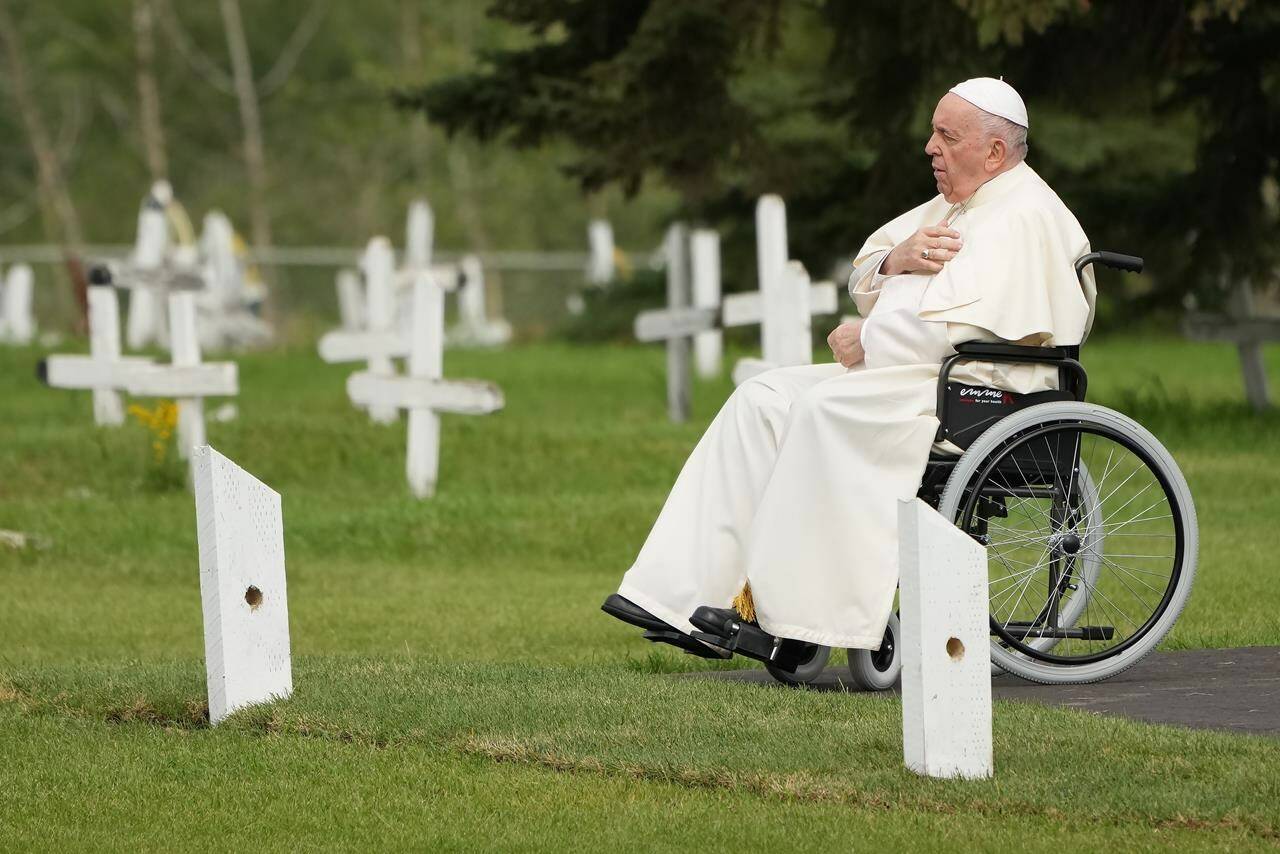 Pope Francis prays at a gravesite at the Ermineskin Cree Nation Cemetery in Maskwacis, Alta., during his papal visit across Canada on Monday, July 25, 2022. Pope Francis delivered a historic apology to survivors of the country’s residential school system, the majority of which were operated by the Catholic Church. THE CANADIAN PRESS/Nathan Denette