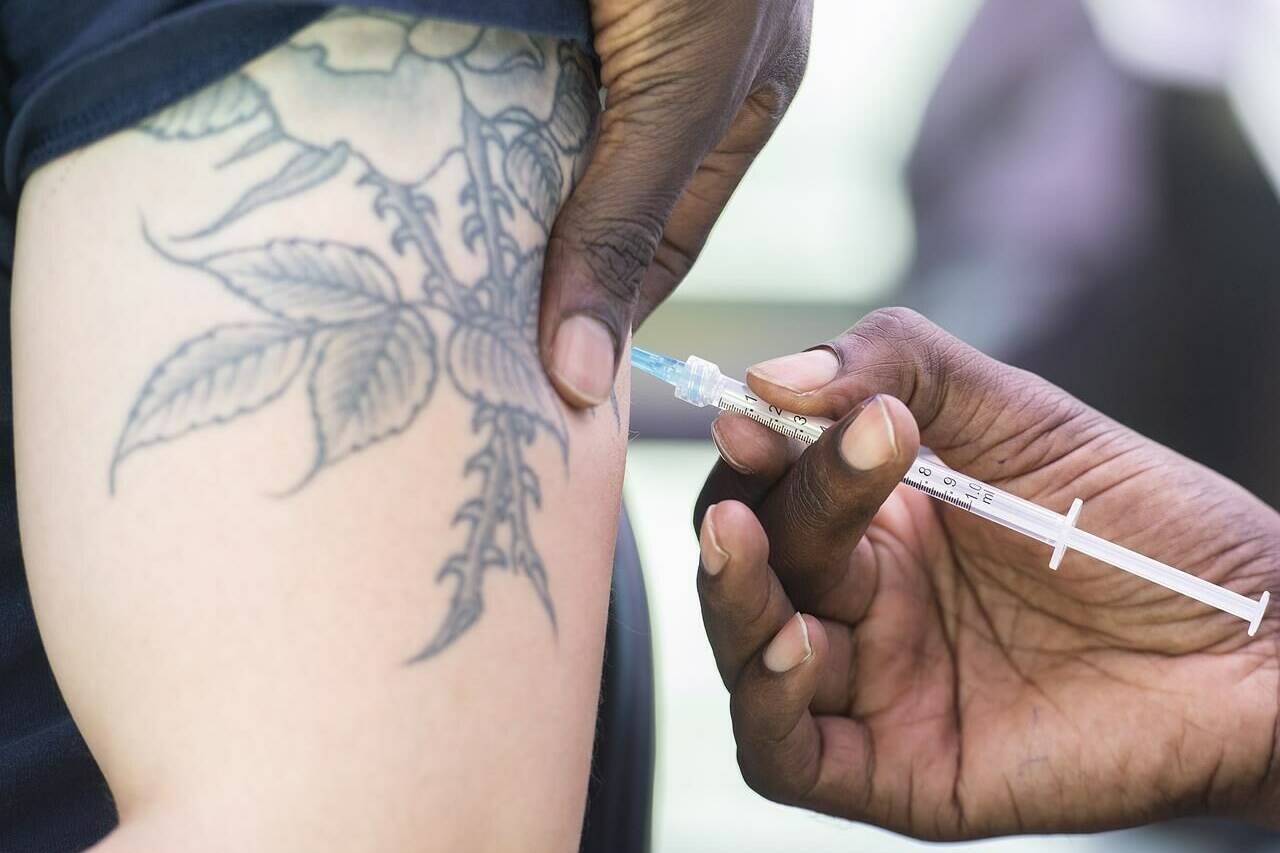 A man receives a monkeypox vaccine at an outdoor walk-in clinic in Montreal, Saturday, July 23, 2022. Chief public health officer Dr. Theresa Tam says Canadians should practice safe sex and reduce the number of sexual partners to reduce the spread of monkeypox.THE CANADIAN PRESS/Graham Hughes