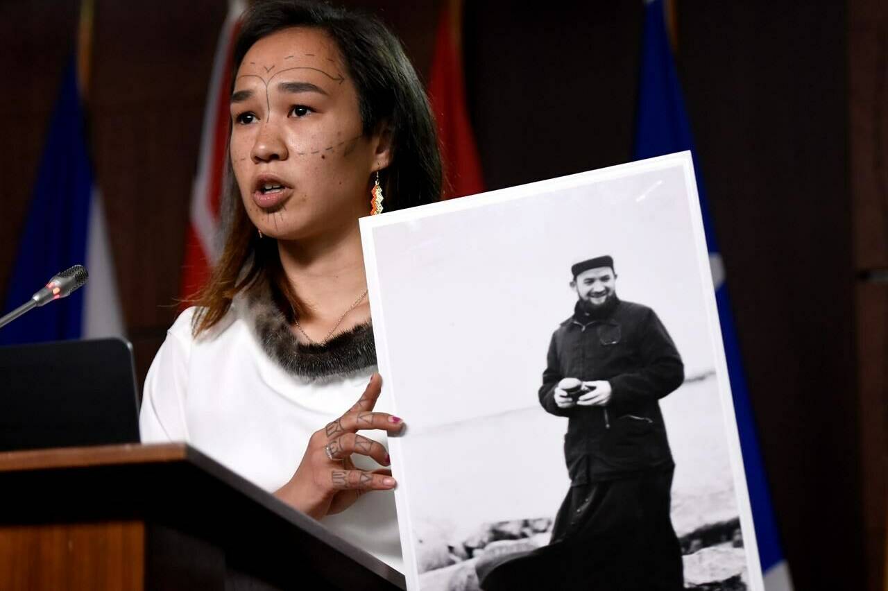 NDP MP Mumilaaq Qaqqaq holds a photo of Fr. Johannes Rivoire, who is wanted in Canada for abusing children in Nunavut but now resides in France, on Parliament Hill in Ottawa, on Thursday, July 8, 2021. Canada has requested France extradite the priest accused of sexually abusing children in Nunavut.THE CANADIAN PRESS/Justin Tang