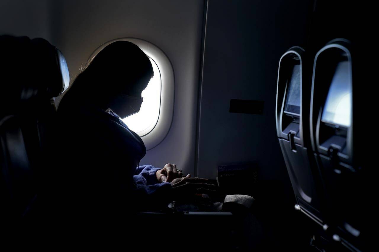 FILE - In this Wednesday, Feb. 3, 2021, file photo, a passenger wears a face mask she travels on a flight. (AP Photo/Charlie Riedel, File)