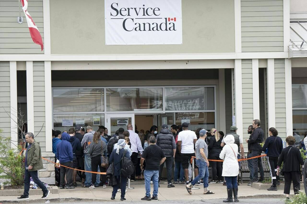 Travellers keen to get their passports in hand in time for take-off will now be able to request their mail-in applications be transferred to any of the more than 300 local Service Canada centres for processing. People line up at the passport office, Tuesday, June 21, 2022 in Laval, Que. THE CANADIAN PRESS/Ryan Remiorz