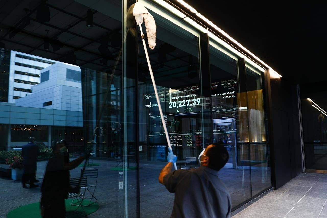 A sign board displays the TSX as a custodian cleans the windows of the Richmond Adelaide Centre in the financial district in Toronto on Wednesday, September 29, 2021. THE CANADIAN PRESS/Evan Buhler