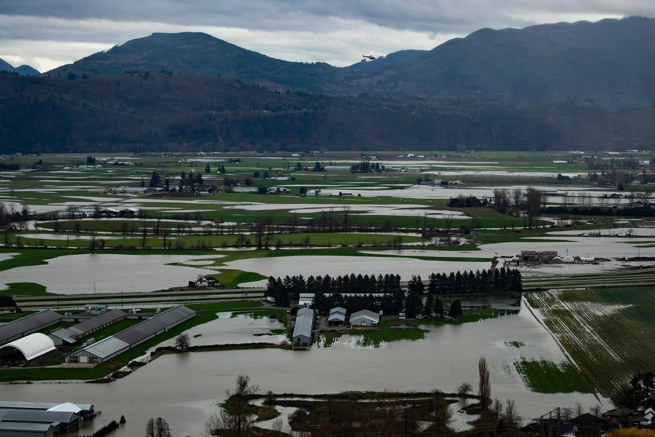 A helicopter flies over flooded farmland in Abbotsford, B.C., on Wednesday, Dec. 1, 2021. THE CANADIAN PRESS/Darryl Dyck