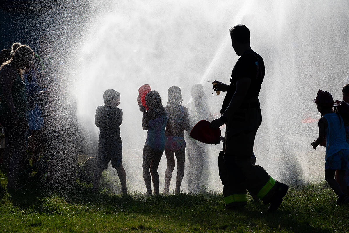 Children play in a sprinkler to cool off in Maple Ridge. (Oliver Rathonyi-Reusz/Special to The News)