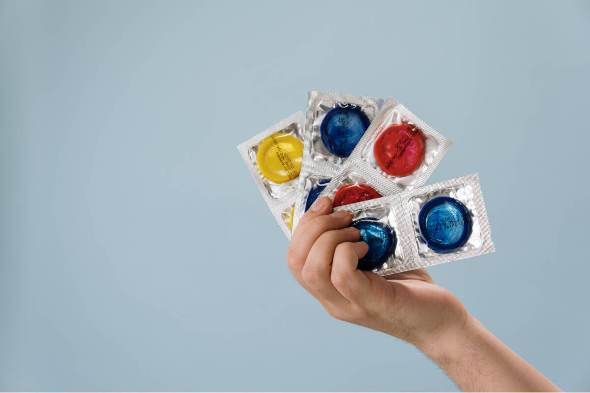 A person holding condoms. (Pexels photo)