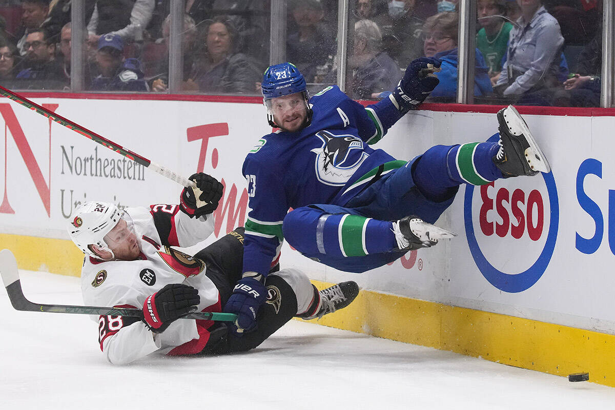 Ottawa Senators’ Connor Brown, left, and Vancouver Canucks’ Oliver Ekman-Larsson, of Sweden, collide during the first period of an NHL hockey game in Vancouver, B.C., Tuesday, April 19, 2022. THE CANADIAN PRESS/Darryl Dyck