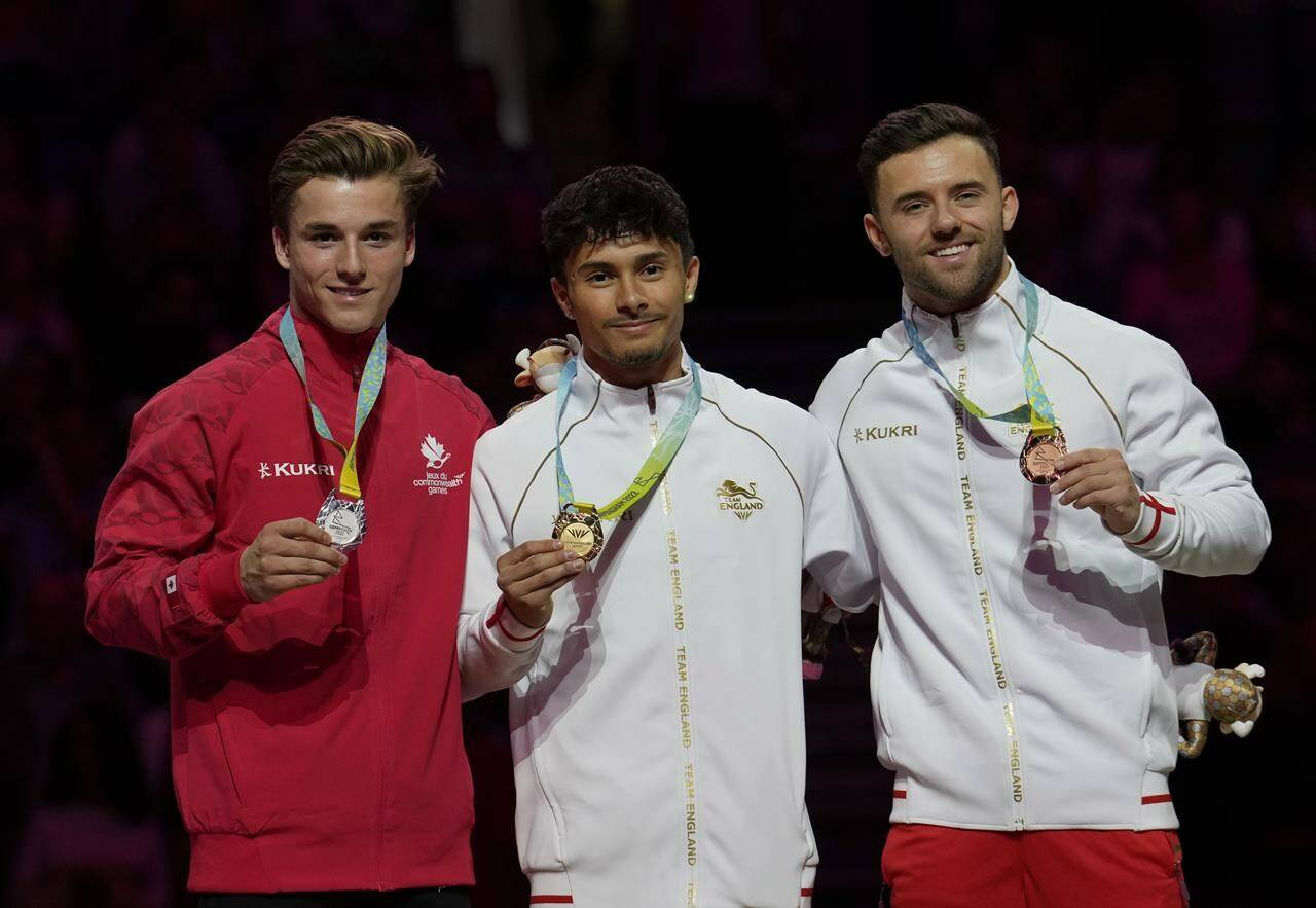 Jake Jarman of Team England, centre, Felix Dolci of Team Canada and Giarnni Regini-Moran of Team England celebrate with their gold, silver and bronze medals respectively for the apparatus Men’s final Floor Exercise finals at the Commonwealth Games, in Birmingham, England, Monday, Aug.1, THE CANADIAN PRESS/AP/Manish Swarup