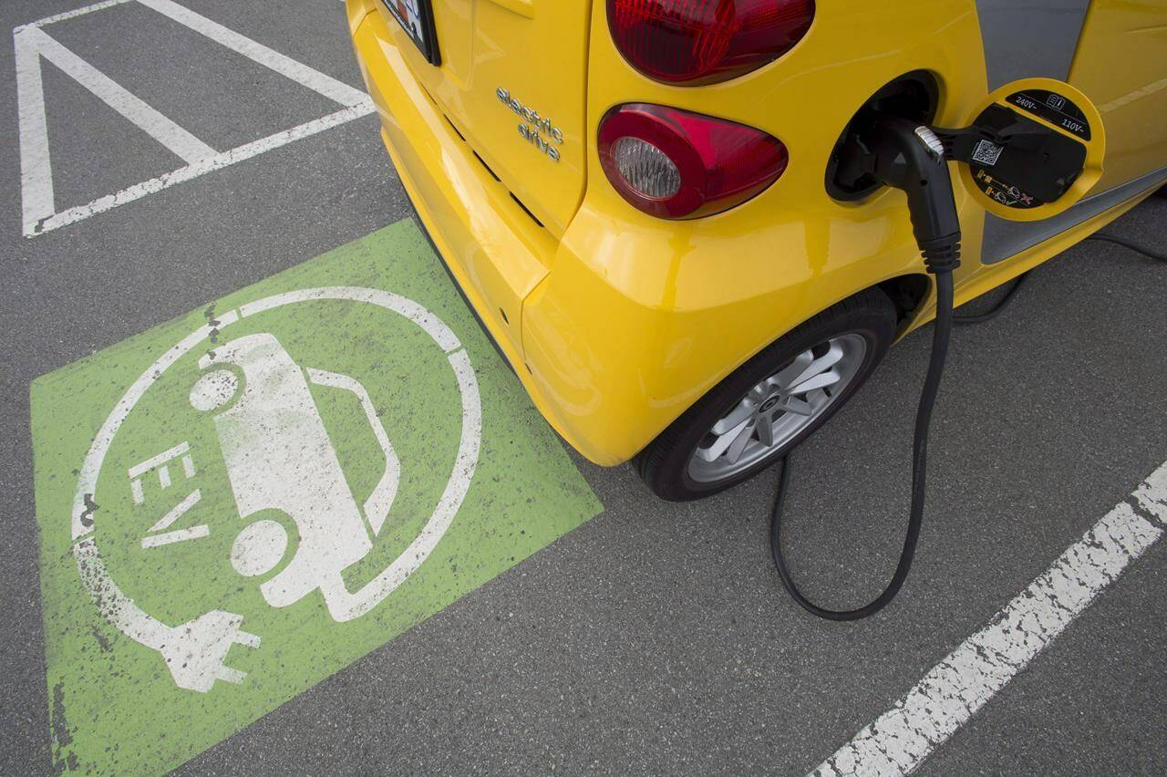 A electric car is seen getting charged at parking lot in Tsawwassen, near Vancouver B.C., Friday, April, 6, 2018. THE CANADIAN PRESS/Jonathan Hayward