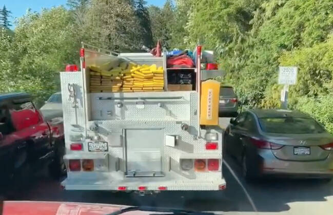 A Cultus Lake Fire Department engine tries to thread the needle through traffic and parked cars on a busy day last weekend. (Cultus Lake FD screenshot)