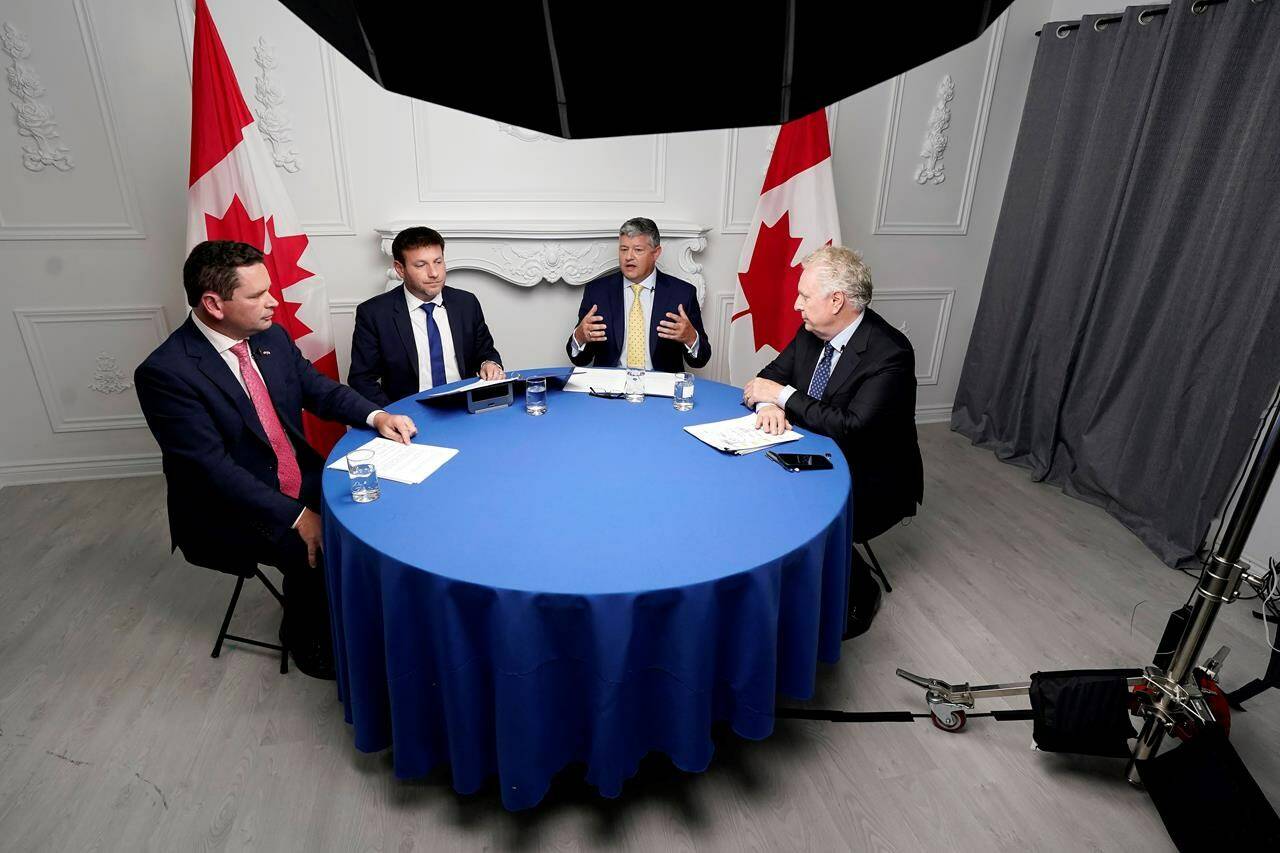 Debate moderator Rob Batherson, left to right, and Conservative leadership candidates Roman Baber, Scott Aitchison and Jean Charest are shown during the Conservative party leadership debate in Ottawa on Wednesday, August 3, 2022. THE CANADIAN PRESS/Adrian Wyld