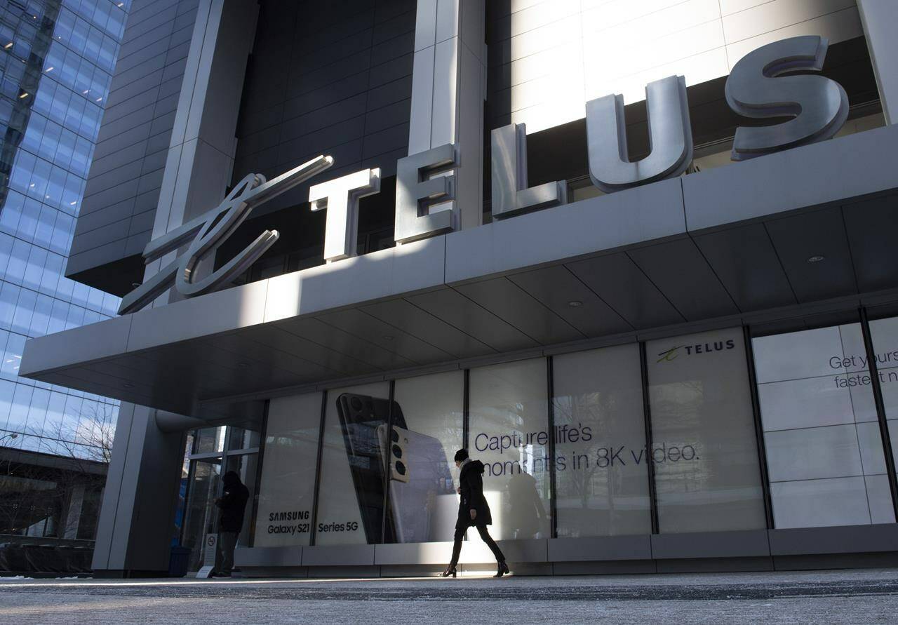 A woman walks in front of the Telus head office is shown in Toronto on Thursday, February 11, 2021. THE CANADIAN PRESS/Frank Gunn