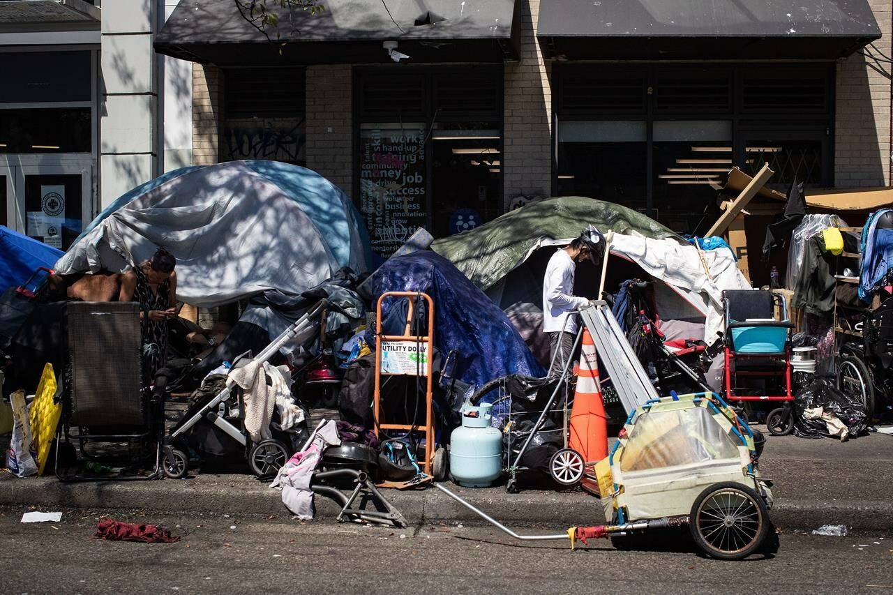 Tents line the sidewalk on East Hastings Street in the Downtown Eastside of Vancouver, on Thursday, July 28, 2022. People living in a growing tent community along the street have been handed notices advising that the tents and other structures are about to be removed. THE CANADIAN PRESS/Darryl Dyck