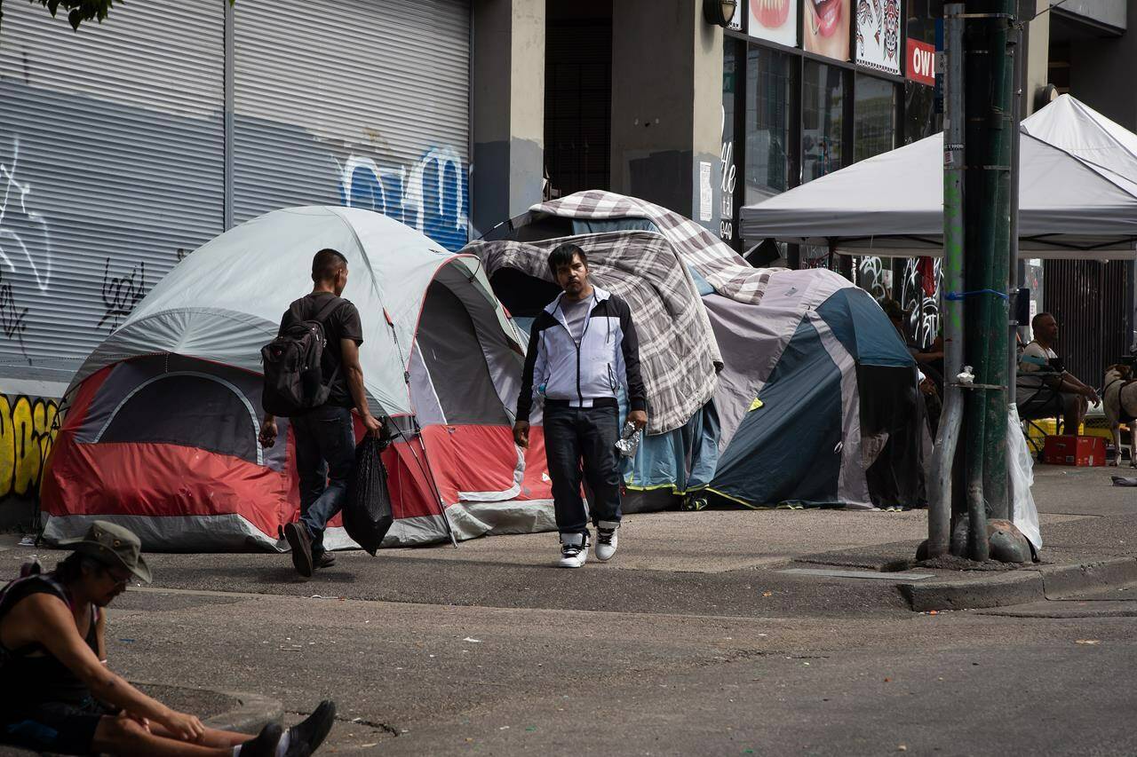 Tents line the sidewalk on East Hastings Street in the Downtown Eastside of Vancouver, where city workers started efforts to clear the encampment on Tuesday, August 9, 2022. The city’s fire chief issued an order last month requiring the tents be cleared because of an extreme fire safety hazard. THE CANADIAN PRESS/Darryl Dyck