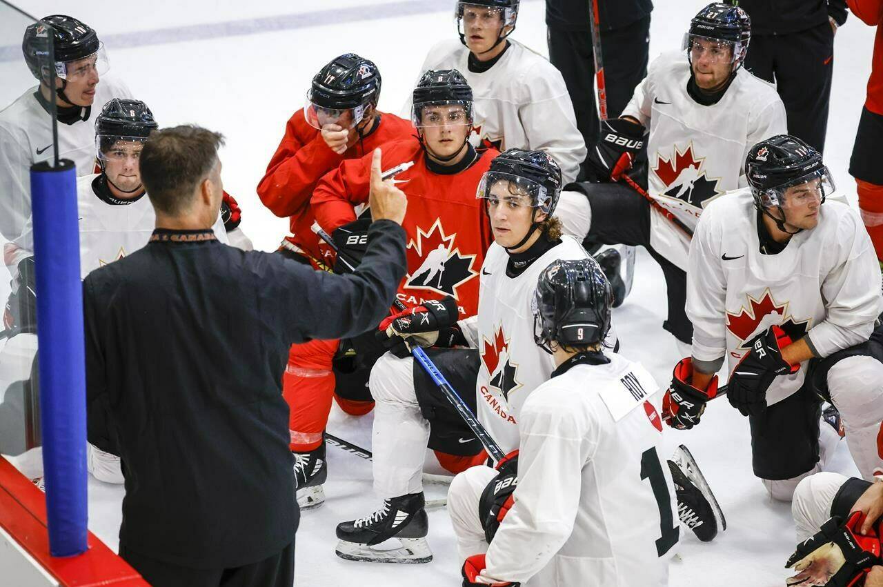 Canada’s National Junior Team assistant coach Michael Dyck, left, gives instructions during a training camp practice in Calgary, Tuesday, Aug. 2, 2022.THE CANADIAN PRESS/Jeff McIntosh