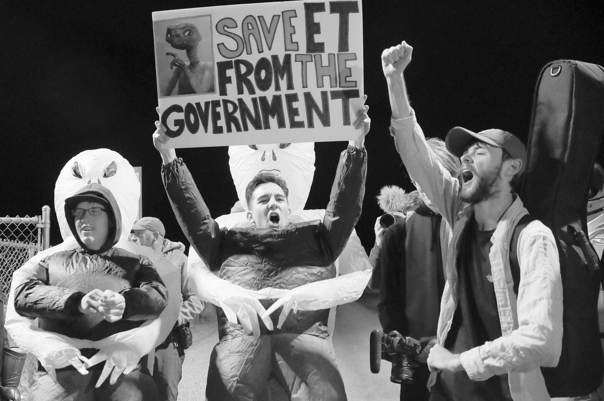 Mario Rayna, center, chants with others at an entrance to the Nevada Test and Training Range near Area 51 Friday, Sept. 20, 2019, near Rachel, Nev. People gathered at the gate inspired by the "Storm Area 51" internet hoax. (AP Photo/John Locher)