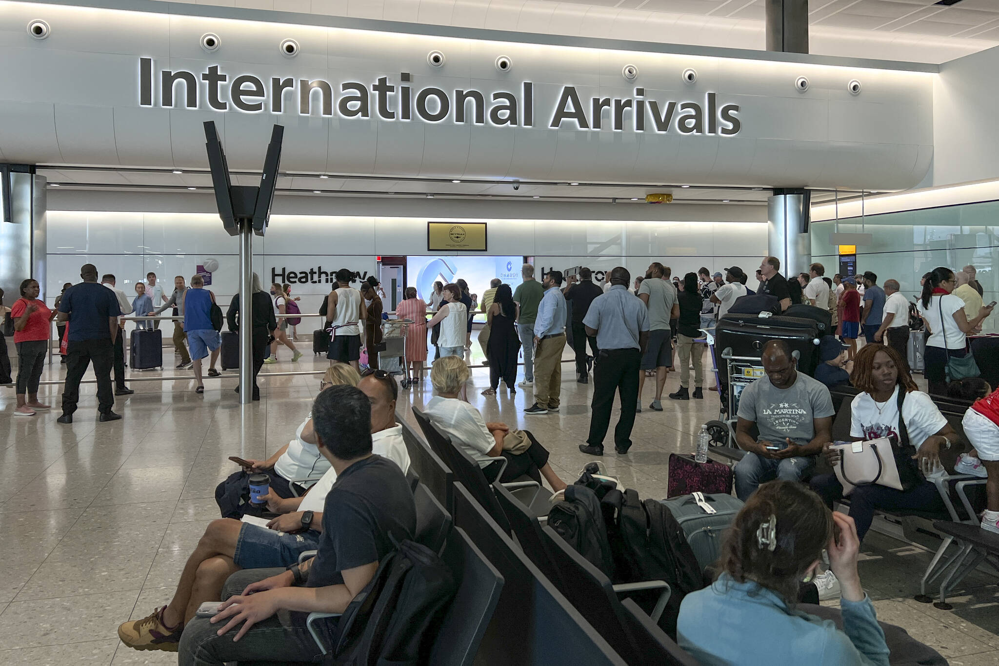 Travellers at Heathrow airport, in London, Wednesday, July 13, 2022. Heathrow Airport has introduced a cap on passenger numbers this summer as the aviation sector struggles to cope with demand for travel. No more than 100,000 daily passengers will be able to depart from July 12 until Sept. 11, the west London airport announced. (AP Photo/Alberto Pezzali)