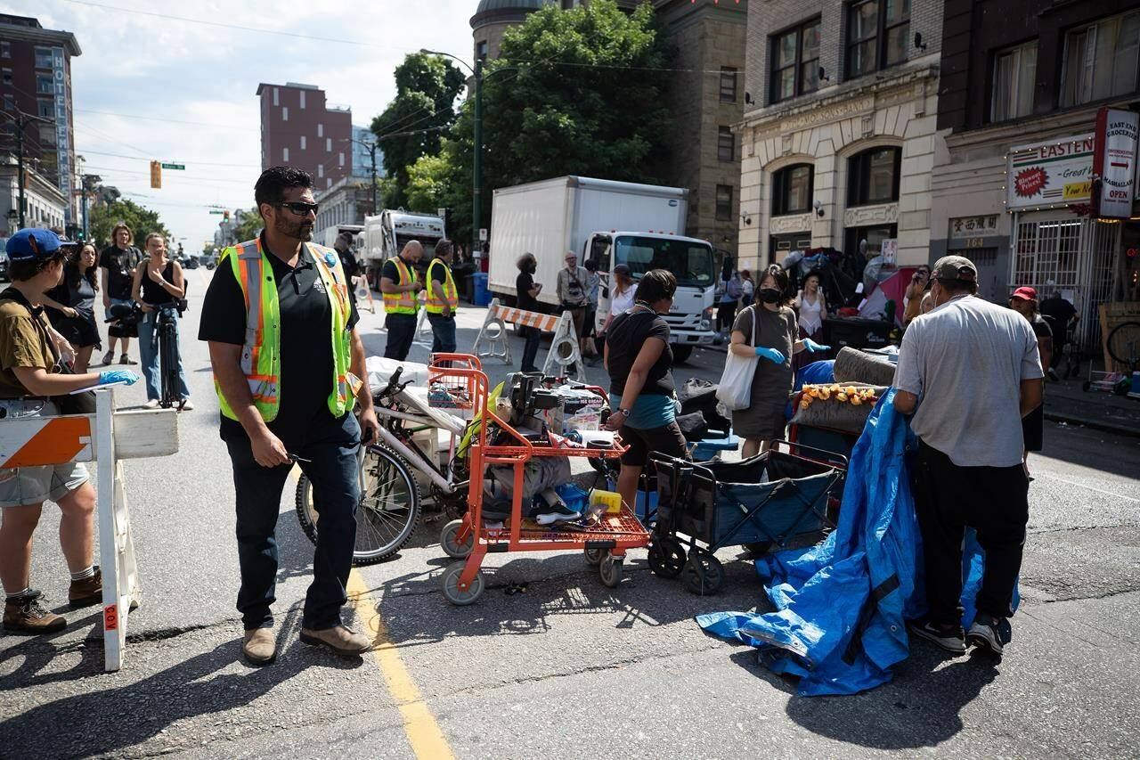 A person’s belongings are placed on the street to be moved to storage after his tent was cleared from the sidewalk at a sprawling homeless encampment on East Hastings Street in the Downtown Eastside of Vancouver, on Tuesday, August 9, 2022. Police say a charge of assault with a weapon has been laid against a woman after officers in Vancouver were allegedly attacked in the same area as a tent encampment was being removed from the city’s Downtown Eastside. THE CANADIAN PRESS/Darryl Dyck