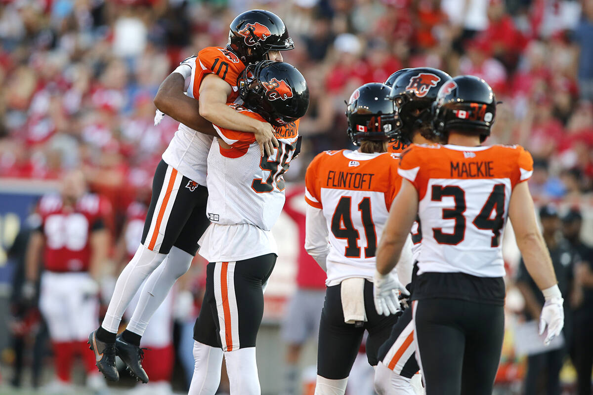 BC Lions kicker Sean Whyte, left, celebrates his winning field goal with defensive end Obum Gwacham (98) near game end CFL football action against the Calgary Stampeders in Calgary, Saturday Aug. 13, 2022. THE CANADIAN PRESS/Larry MacDougal