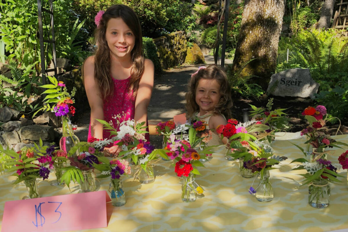Georgia Poitras, 9, and her sister Rosie, 5, sell flowers at their nana’s house in Oak Bay to raise funds for the Island Kids Cancer Association. (Courtesy Jen Poitras)
