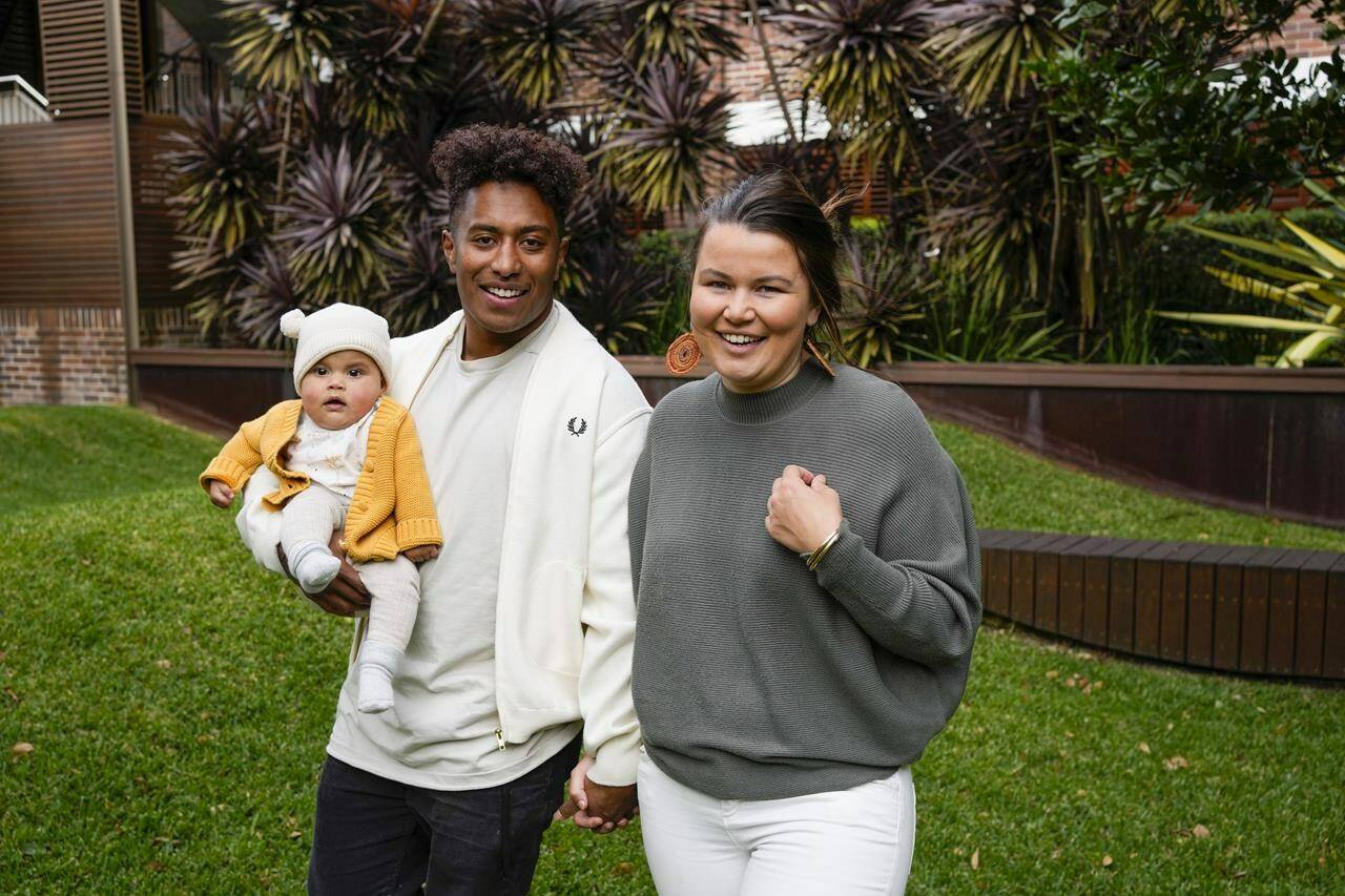 Ellia Green with his partner Vanessa Turnbull-Roberts and their daughter Waitui pose in Sydney, Australia, Monday, Aug. 15, 2022. Green, one of the stars of Australia’s gold medal-winning women’s rugby sevens team at the 2016 Olympics, has transitioned to male. The 29-year-old, Fiji-born Green is going public in a video at an international summit aimed at ending transphobia and homophobia in sport. The summit is being hosted in Ottawa as part of the Bingham Cup rugby tournament. (AP Photo/Mark Baker)