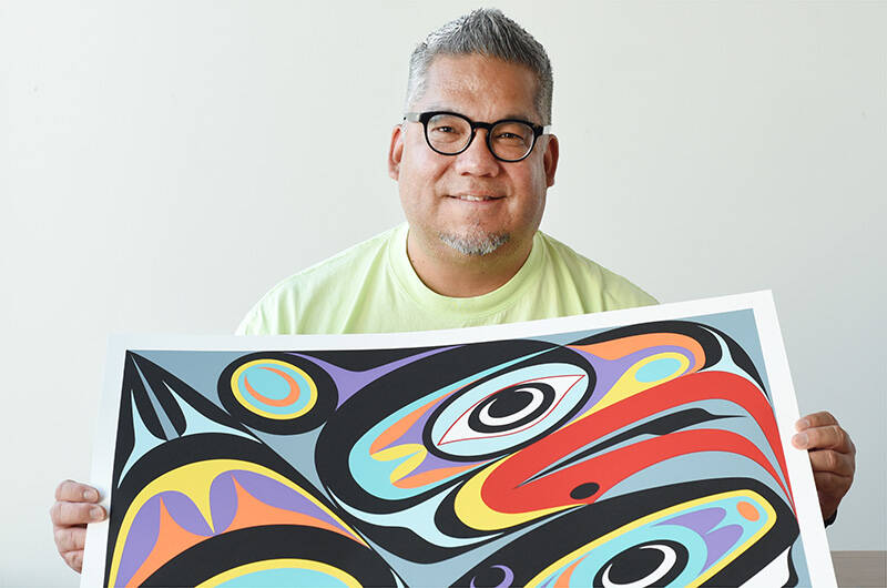 July 13, 2022 - Indigenous artist Maynard Johnny Jr. poses with one of his prints in his Duncan studio. Don Denton photo.