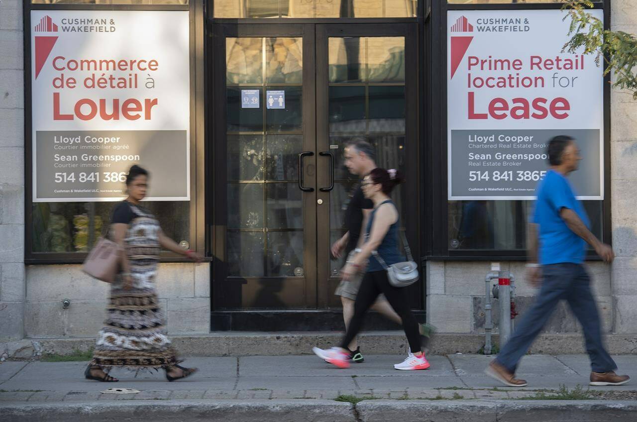 People walk by bilingual signs for a commercial space for lease in the city of Westmount on the island of Montreal on August 5, 2022. Statistics Canada will publish its latest census release on languages this morning. The release, which reflects data from 2017 to 2021, will shed light on the state of English, French, and non-official languages in the country. THE CANADIAN PRESS/Graham Hughes.