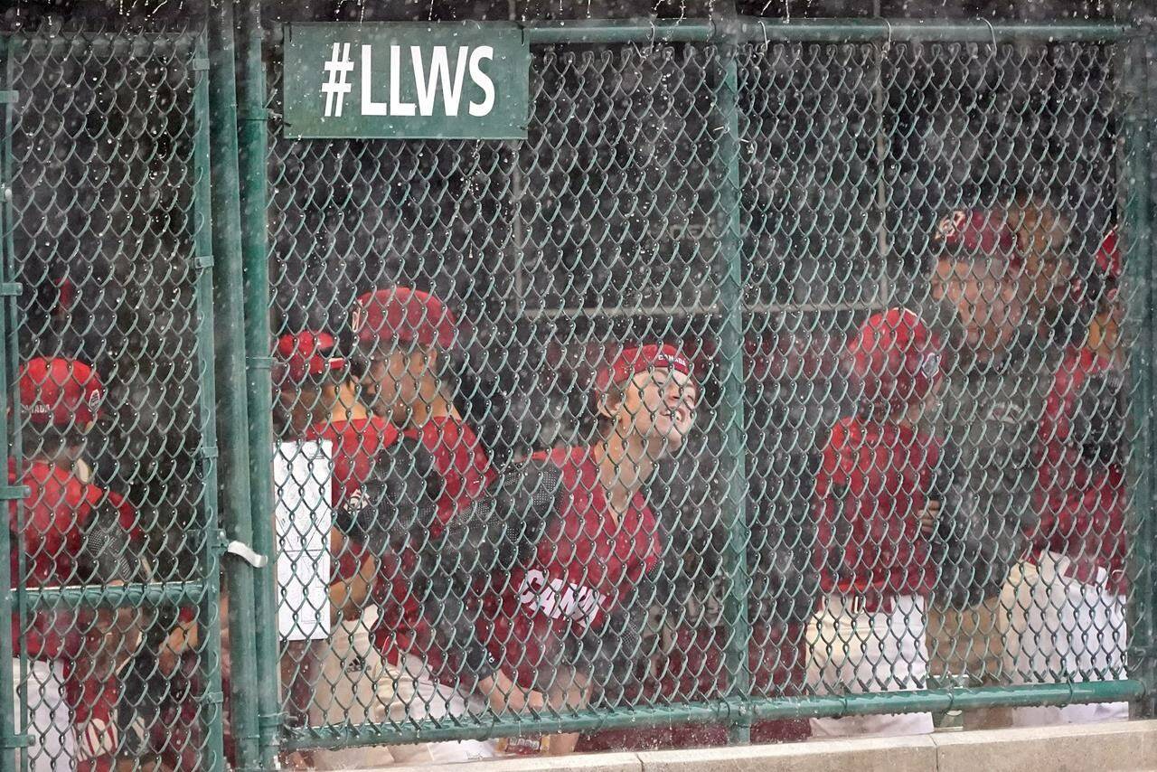 Vancouver, British Columbia, players wait in the dugout during a weather delay in their baseball game against Canada at the Little League World Series in South Williamsport, Pa., Wednesday, Aug. 17, 2022. THE CANADIAN PRESS/AP-Tom E. Puskar
