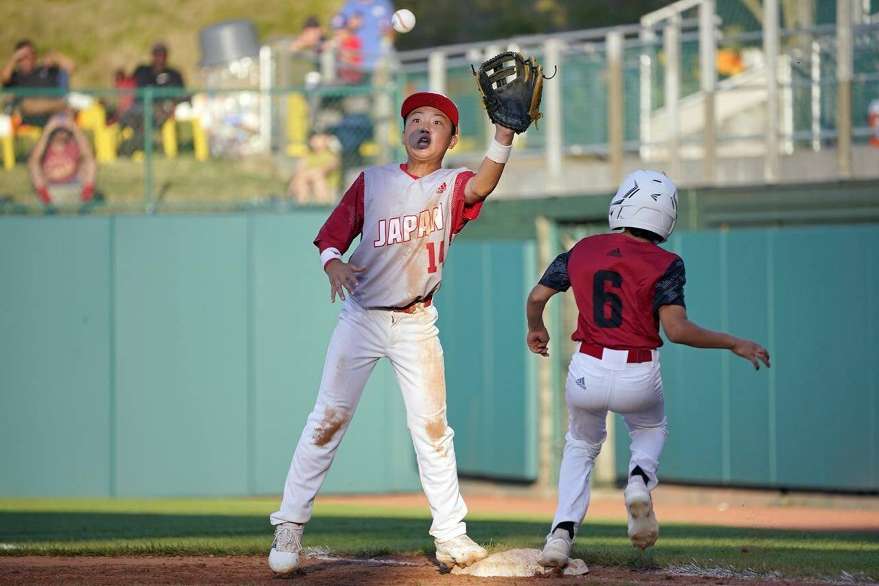 Japan’s Yujiro Kume (14) stretches for the ball as Canada’s Omar Bousmina (6) beats out an infield single during the sixth inning of a baseball game at the Little League World Series tournament in South Williamsport, Pa., Friday, Aug. 19, 2022. (AP Photo/Tom E. Puskar)