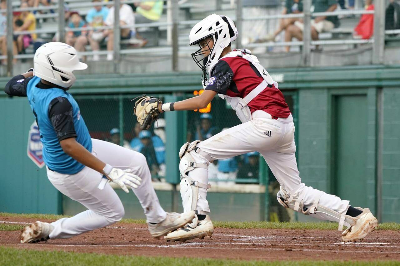 Canada catcher Alden Yu forces out Curacao’s Jay-Dlynn Wiel (7) as he tried to score during the first inning of a baseball game at the Little League World Series tournament in South Williamsport, Pa., Tuesday, Aug. 23, 2022. (AP Photo/Tom E. Puskar)