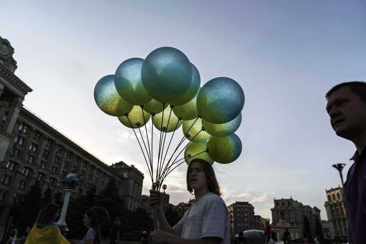 A vendor sells blue and yellow balloons in honor of the country’s National Flag Day, Tuesday, Aug. 23, 2022, at Maidan Square in Kyiv, Ukraine. Kyiv authorities have banned mass gatherings in the capital through Thursday for fear of Russian missile attacks. Independence Day, like the six-month mark in the war, falls on Wednesday. (AP Photo/David Goldman)