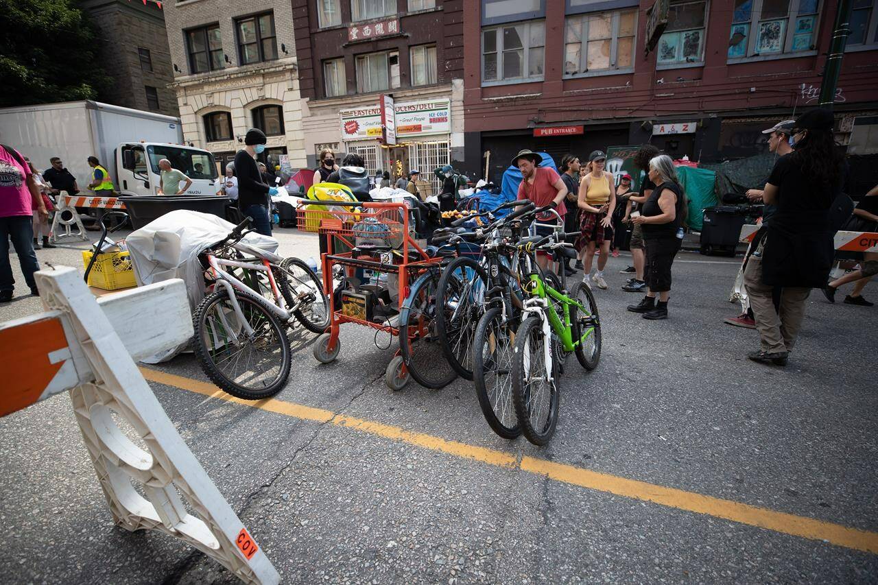 A person’s belongings are placed on the street to be moved to storage after his tent was cleared from the sidewalk at a sprawling encampment on East Hastings Street in the Downtown Eastside of Vancouver, on Tuesday, Aug. 9, 2022. THE CANADIAN PRESS/Darryl Dyck